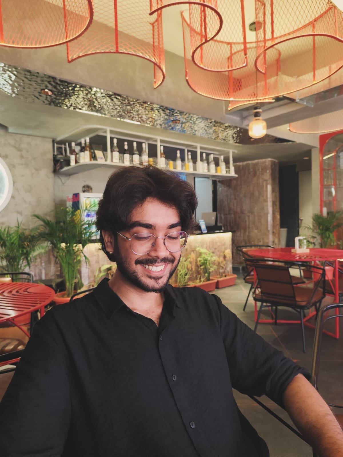 Shubham smiling at a cafe